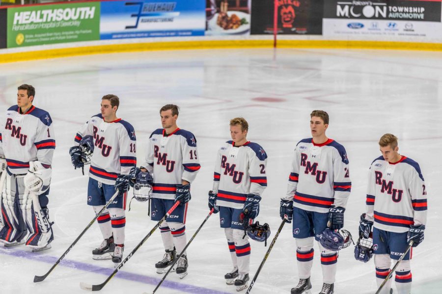 The Robert Morris Mens hockey team stands in unison at the blue line during the playing of the National Anthem at Colonials Arena.