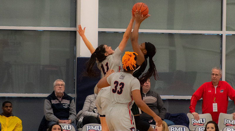 Natalie Villaflor goes for the block while Nneka Ezeigbo stands by against Wagner. Moon Twp, PA. (RMU Sentry Media/Michael Sciulli)
