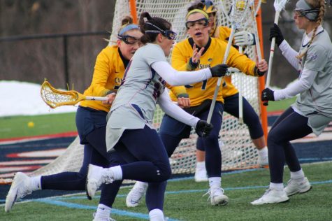 Jerica Obee fights to get into the crease against Canisius. Photo credit: Tyler Gallo