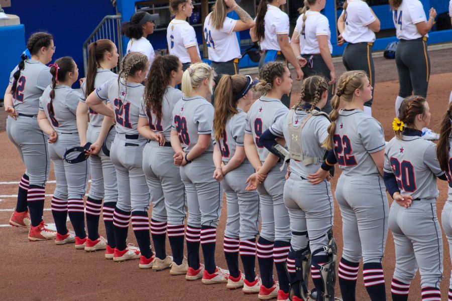 The+RMU+Softball+team+stands+for+the+National+Anthem+in+their+game+against+Pitt+on+March+30%2C+2022+Photo+credit%3A+Tyler+Gallo