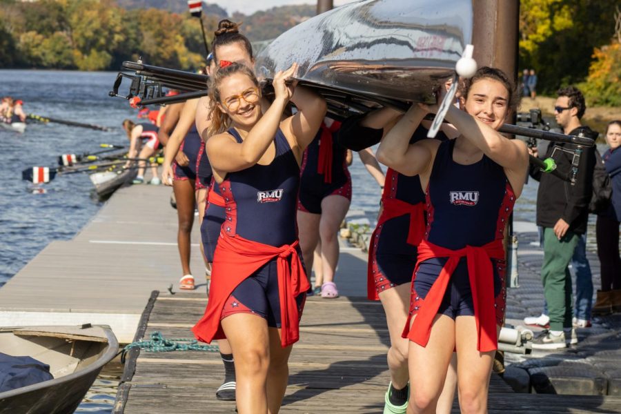 A Robert Morris Varsity 8 boat coming off the water after their race at the 2022 Yinzer Cup at the Midge McPhail Boathouse. 